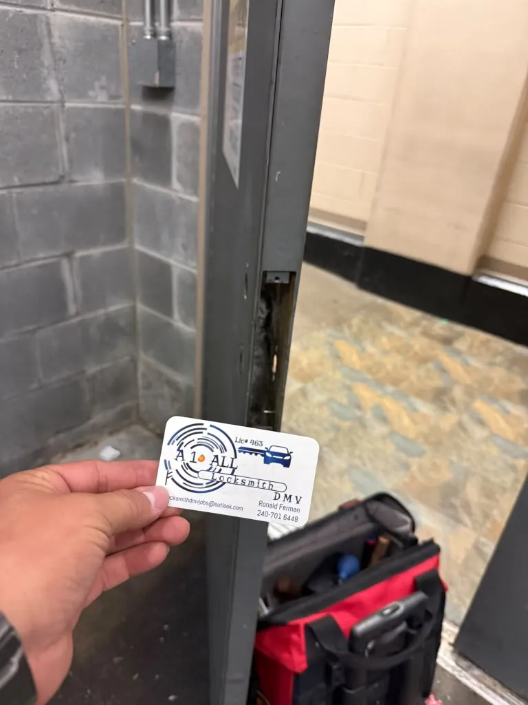 A1 All Locksmith DMV business card beside an open metal door with its lock case removed and a tool bag below